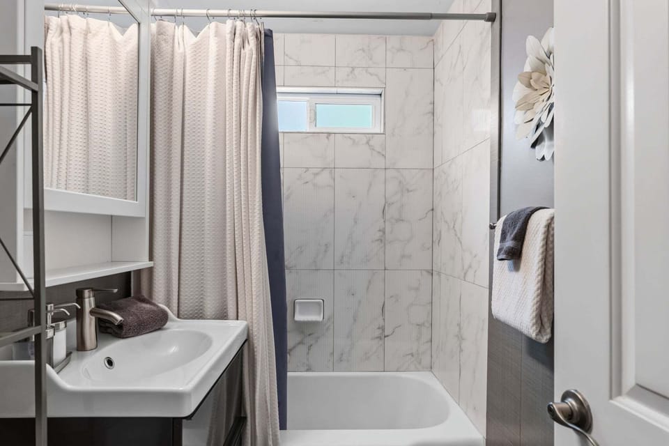 Crisp Modern Bath — A spotless shower/tub combo with plush towels and premium amenities creates a spa-like experience in the heart of the cottage. 🛁✨