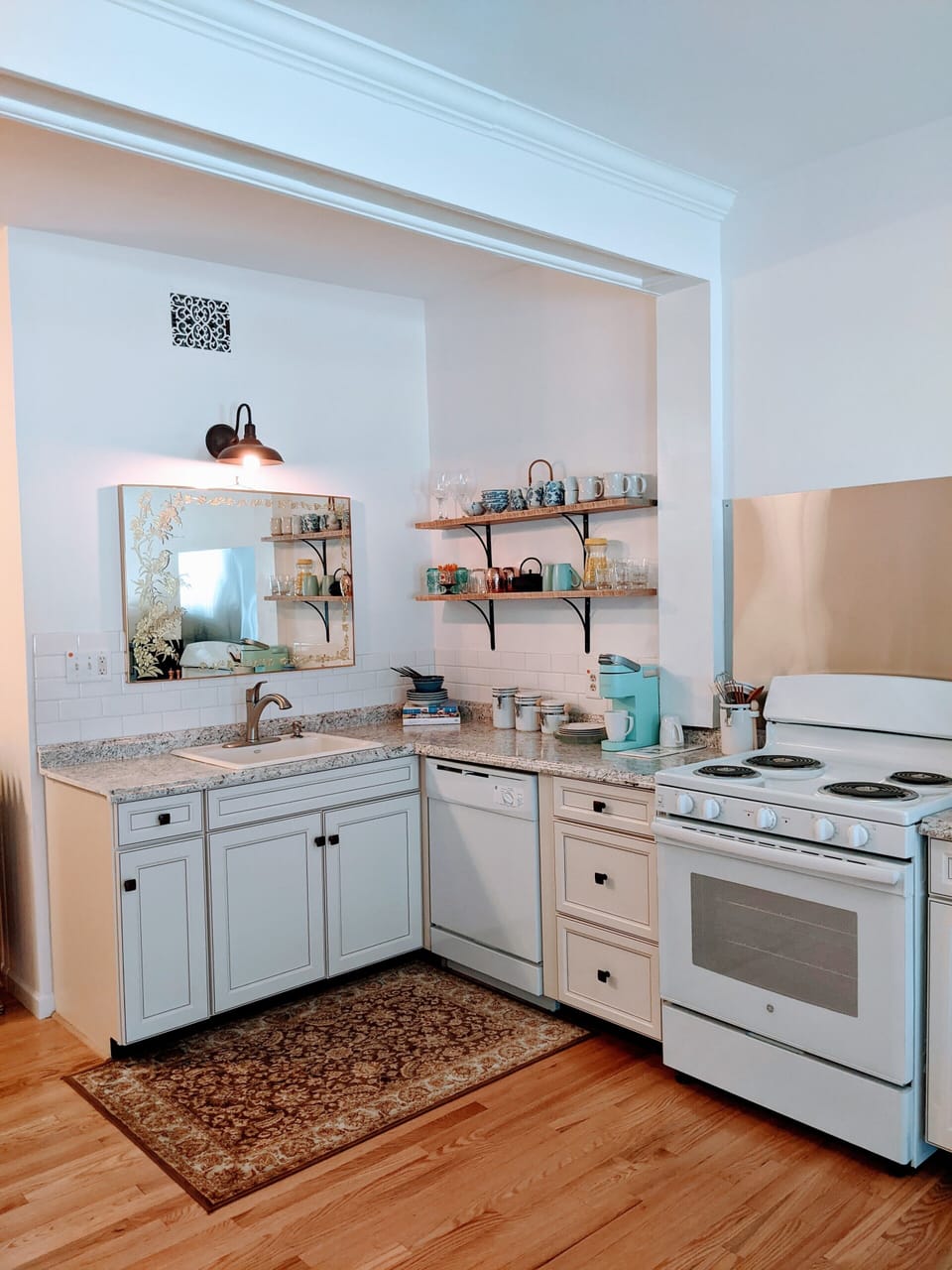 Original wood beam spans across the studio apartment with full kitchen