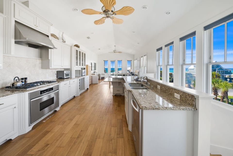 Prepare your favorite meals in this spacious gourmet kitchen featuring granite countertops, premium appliances, and stunning ocean views through every window.