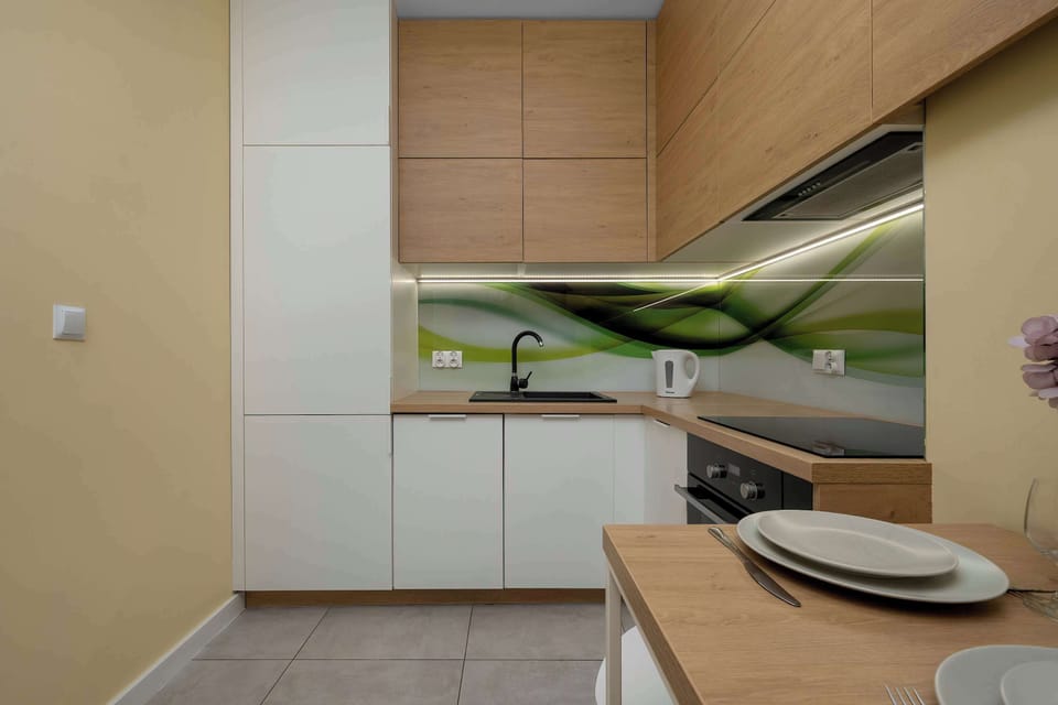The kitchen workspace includes a built-in oven and a modern sink area under warm, integrated lighting.
