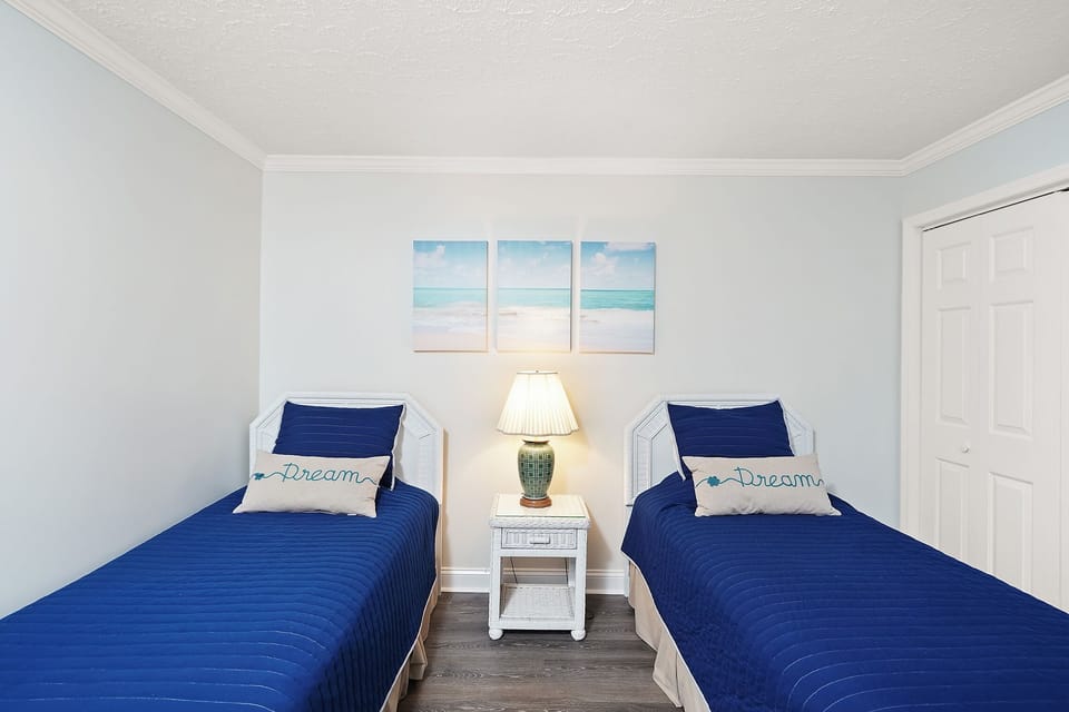 Drift off in your twin bed sanctuary with coastal artwork above and soft bedside lighting creating the perfect dreamy retreat.