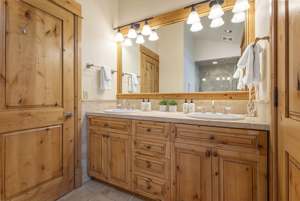 The primary suite bathroom offers guests a double vanity and water closet.