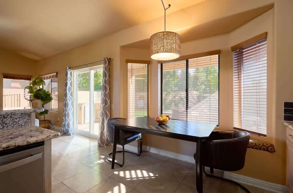 Fully equipped kitchen featuring stainless-steel appliances, kitchen island with bar seating for 3 guests, and an informal dining table with seating for 2 guests.