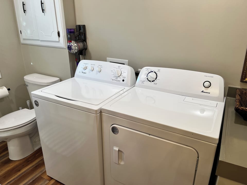 Full size washer and dryer in hallway bath.