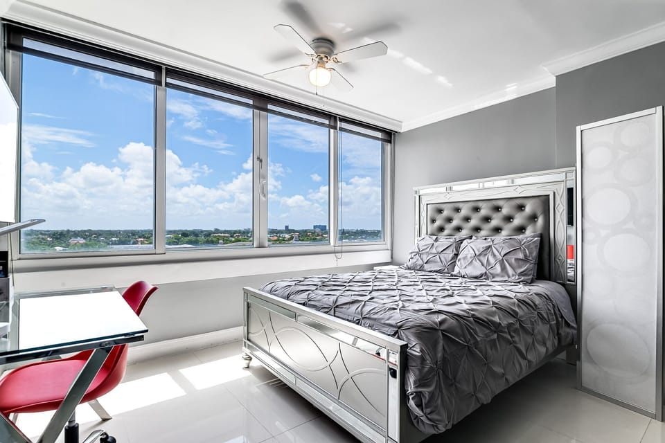 Queen bed  with TV and Desk, located in living room, with screen for privacy