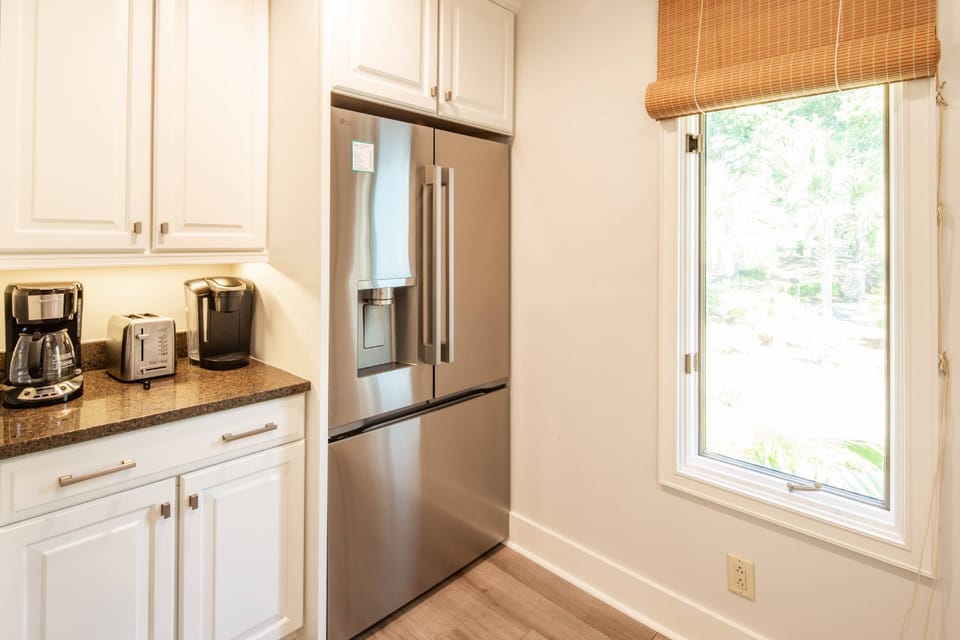 The kitchen has a refrigerator, drip coffee maker, keurig coffee maker and toaster.