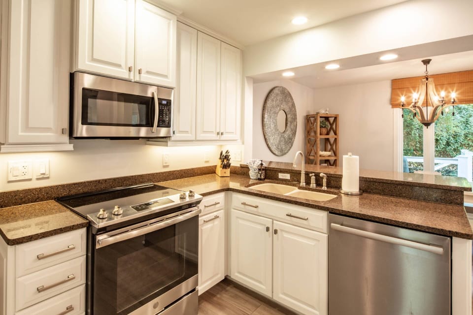 The renovated kitchen boasts stainless steel appliances, white cabinets and granite countertops.