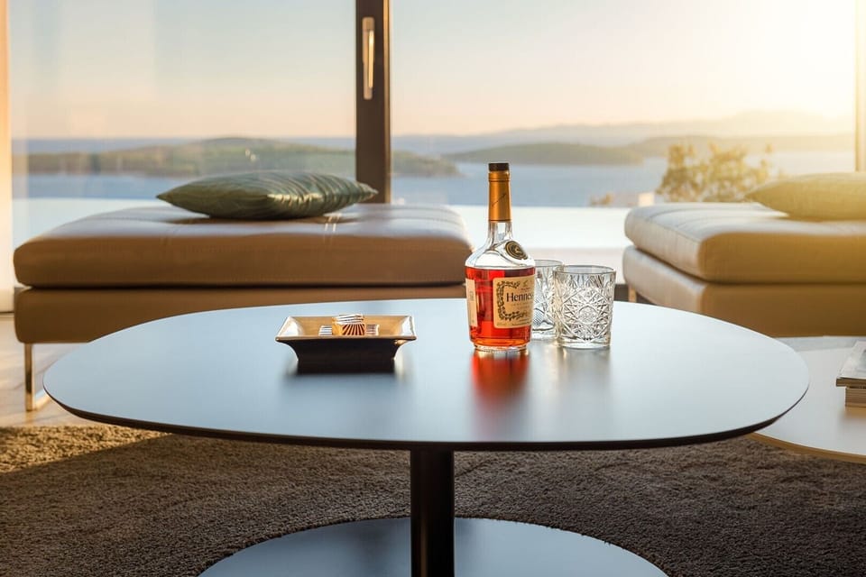 Lounge area with the big smart TV and sofas with direct exit to terrace with heated pool and the sea view in luxury villa Hvar Fantasy