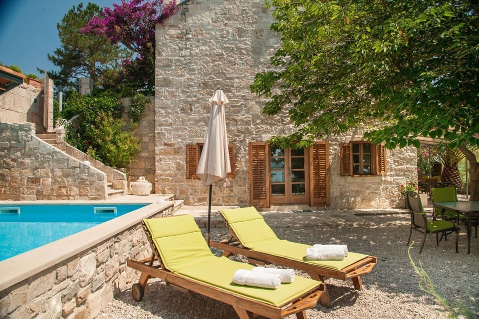 Mediterranean Dalmatia luxury villa Mare in Orebić  by the beach for vacation and rent with private pool and beautiful sunbathing area with wooden deck chairs.