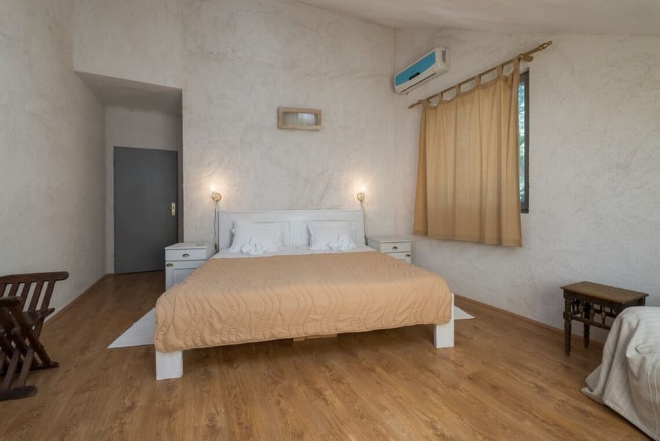 Elegantly decorated bedroom with sea view and Queen-size bed in Brač luxury beachfront villa with pool and parking.