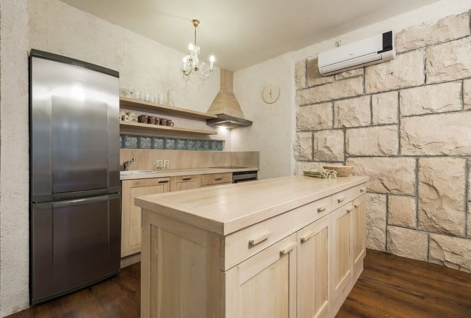 Fully-equipped kitchen and kitchen island in beachfront luxury villa on Brač with pool for vacation and rent.