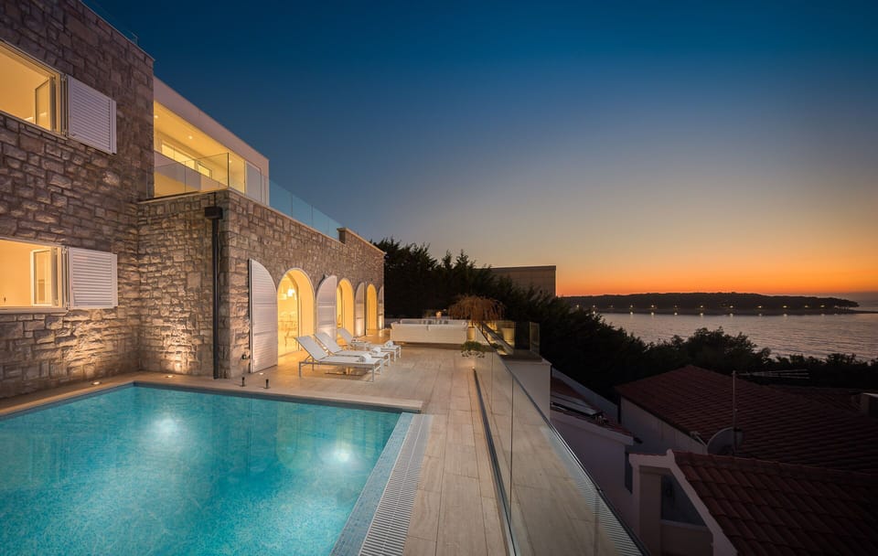 Private outdoor pool surrounded by deck chairs on the outdoor terrace with a view of the sea in the luxury Dalmatia holiday villa Primosten Glamour