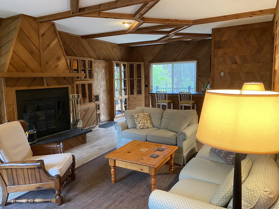 Sunken living room with custom cabinets surrounding a wood burning fireplace