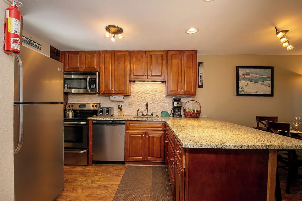 Your fully equipped kitchen awaits with granite counters, stainless appliances, and warm wood cabinets—perfect for preparing memorable meals.