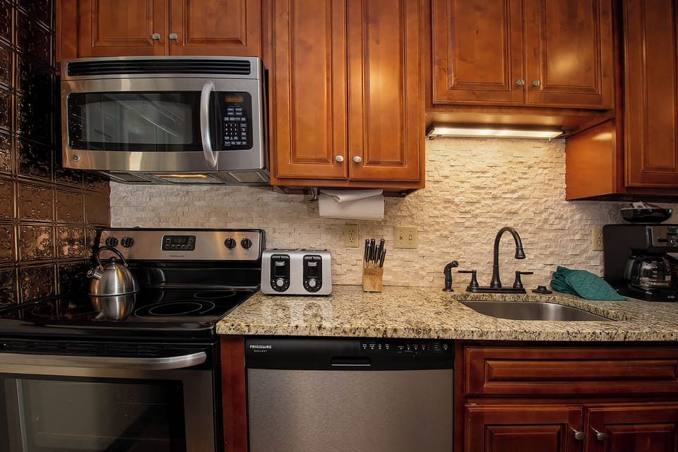 Your gourmet kitchen awaits with granite counters, stainless appliances, and warm cherry cabinets - perfect for creating memorable meals during your stay.