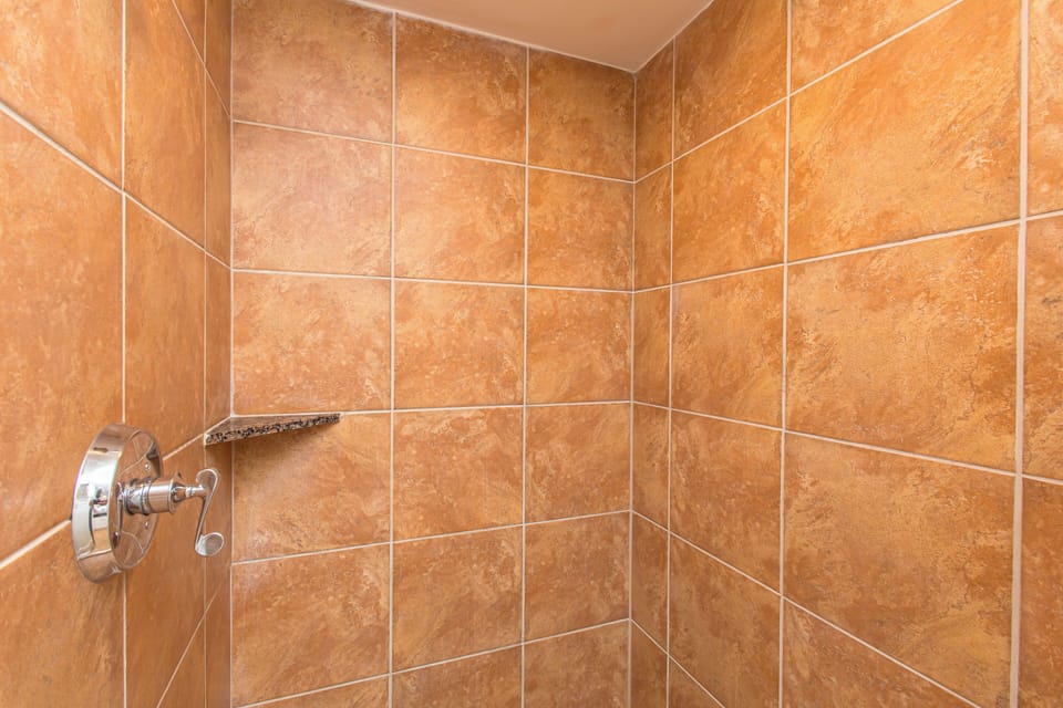 Refresh and recharge in your private shower with warm terracotta tiles and modern fixtures.