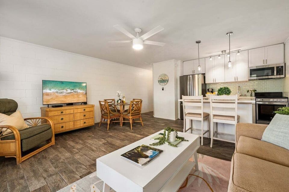 Airy combined living and dining space with natural light, coastal décor, and direct access to leafy outdoor scenery.

Please note: the sofa bed, armchair, and coffee table have been recently replaced.