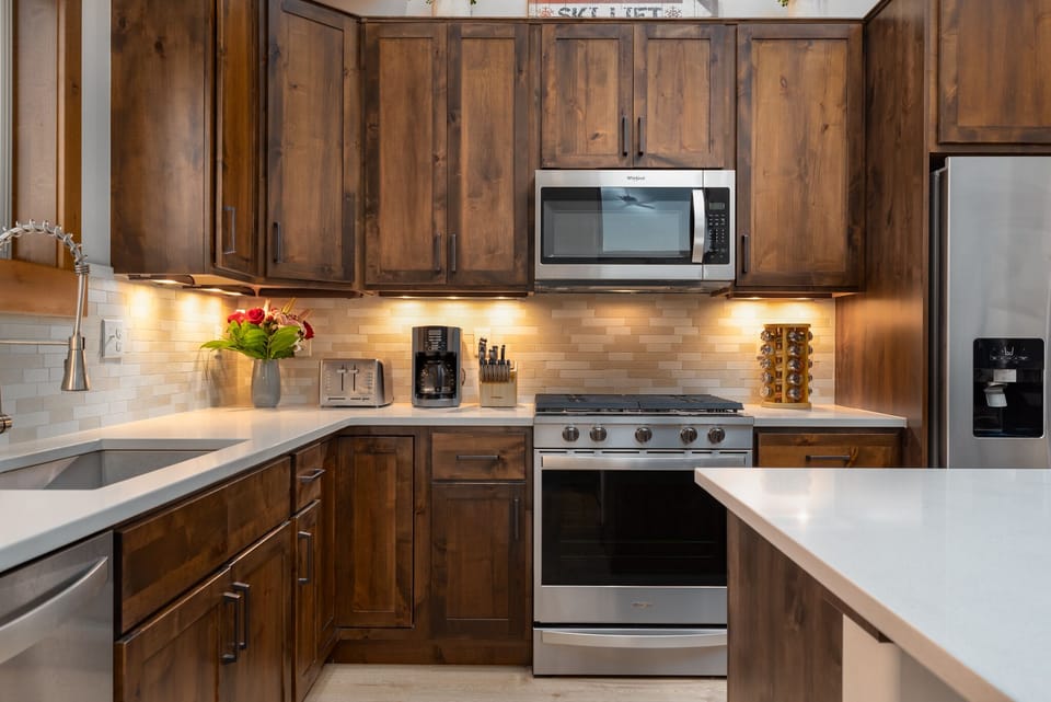 Modern kitchen with stainless steel appliances and everything you need for cooking at home.