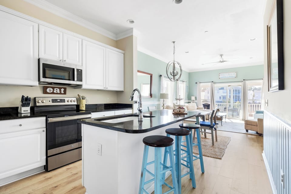 The kitchen is a spacious and functional hub, featuring a large island at its center that provides both extra counter space and a spot for casual meals or entertaining.
