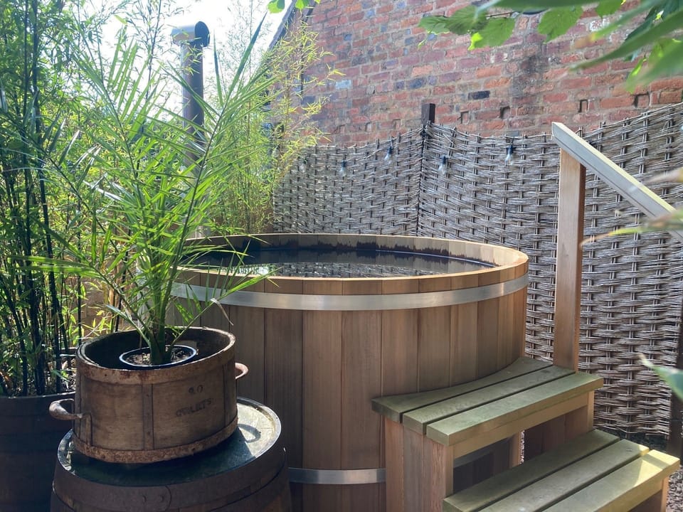 Set in its own private gravelled space with a six foot diameter cedar wood-fired hot tub