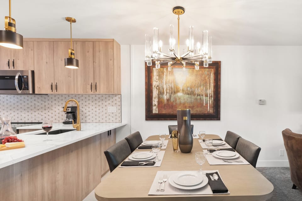 The dining table offers seating for 6 guests and has a gorgeous modern chandelier.