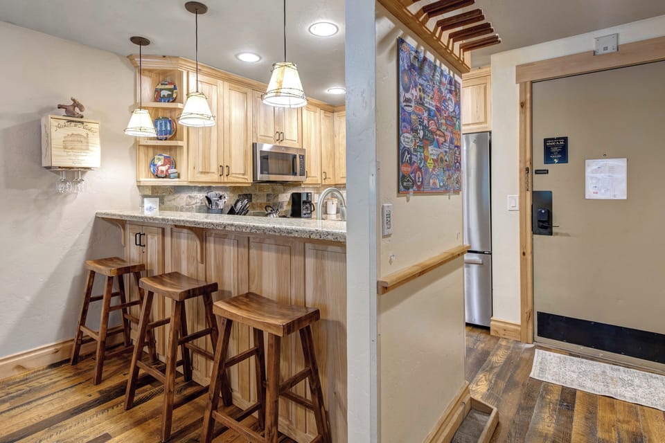 The breakfast bar with seating for 3 on wooden bar stools.