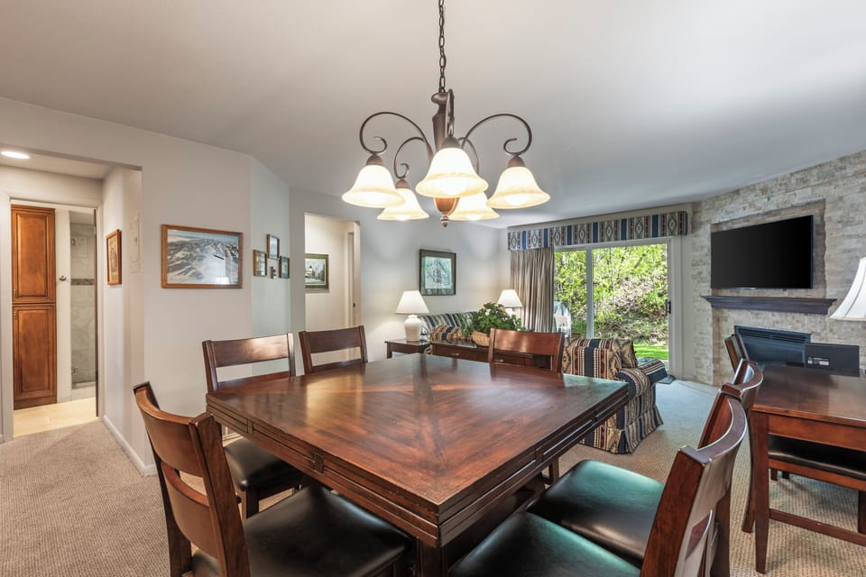 Snow Flower 135's dining area with a wood table, 6 dining chairs, and chandelier.