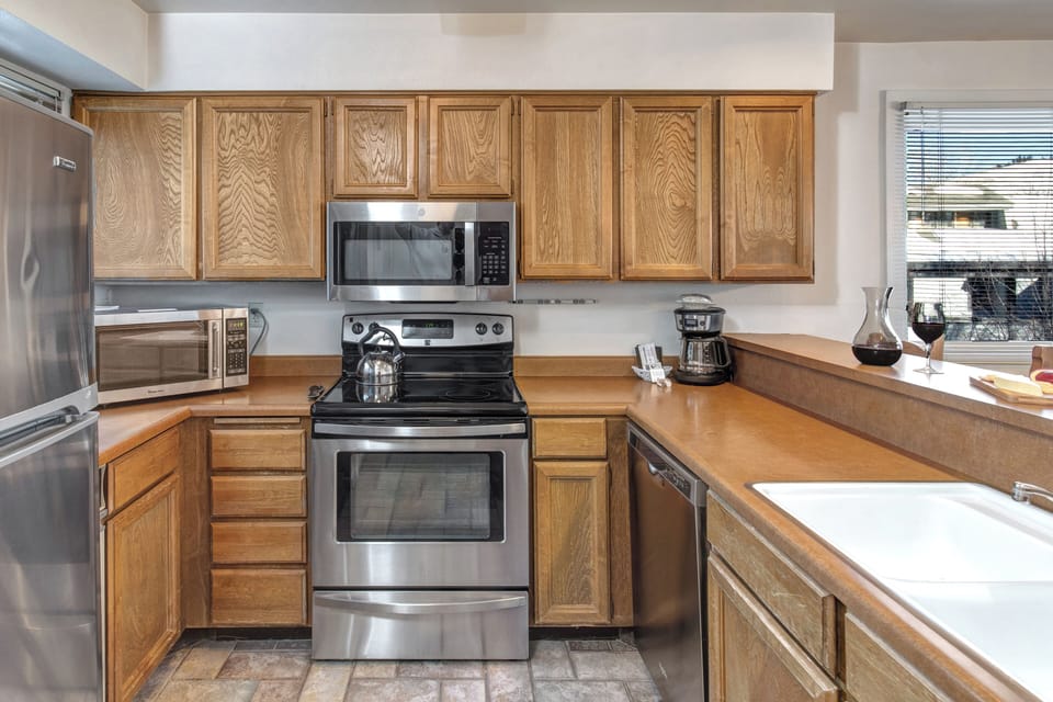 The well-equipped kitchen offers a breakfast bar and stainless steel appliances.