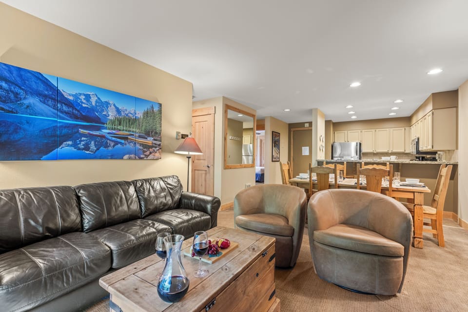 The living room has a comfortable leather couch and two club chairs.