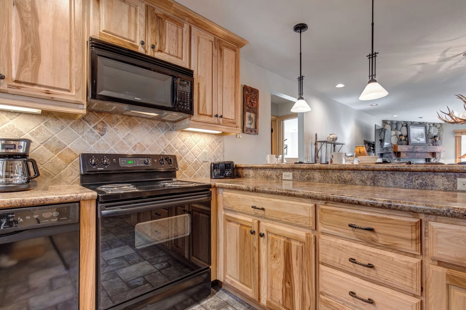 Snow Flower 20 offers a well-equipped kitchen with black appliances and a breakfast bar.