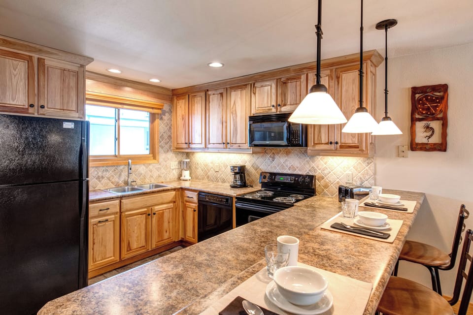 Snow Flower 20 offers a well-equipped kitchen with black appliances and breakfast bar with seating for 3.