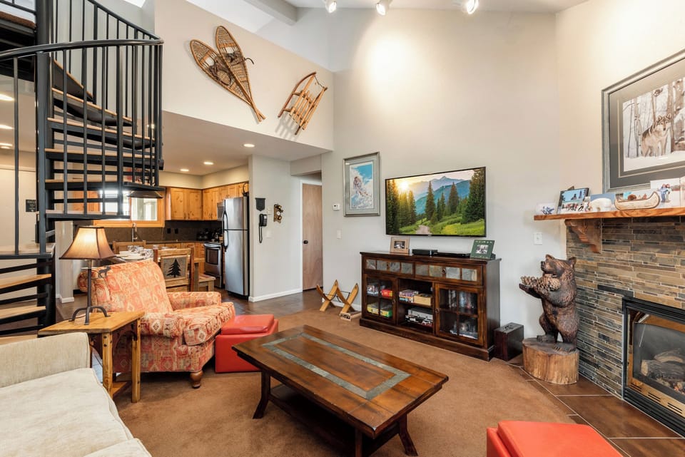 Spacious living room with vaulted ceilings, flat-screen TV, rustic furnishings and mountain décor