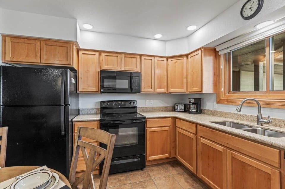 Snow Flower 79 has a well equipped kitchen with black appliances and wooden cabinets.