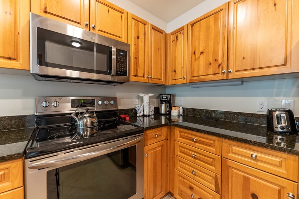 Your fully-equipped kitchen features warm wood cabinets, granite countertops, and modern appliances—everything you need to create memorable meals during your stay.