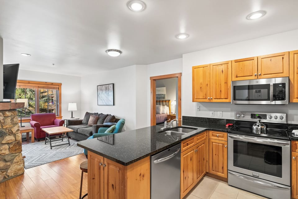 Relax in your open-concept suite with full kitchen, cozy living area, and warm wood finishes creating the perfect mountain retreat.