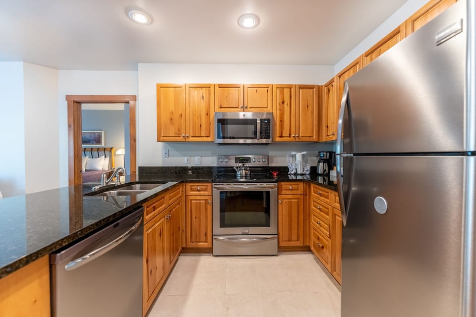Your fully equipped kitchen features warm wood cabinets, granite counters, and stainless appliances for memorable meals together.