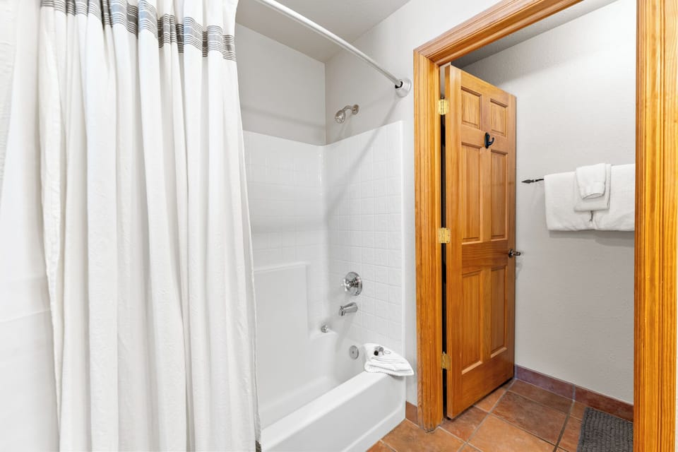 Your private bathroom features a spacious tub-shower combo with fresh linens and charming wood accents for your comfort.
