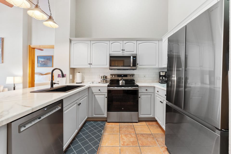 Your fully equipped kitchen features stainless steel appliances and sleek white cabinetry, perfect for preparing meals during your stay.