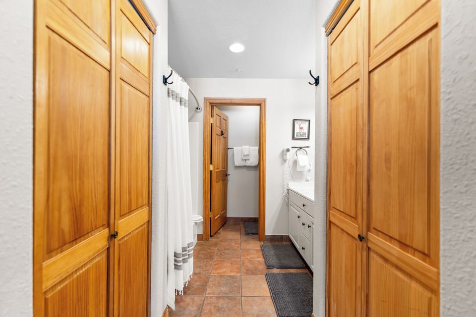 Your private hallway features beautiful wood cabinetry and leads to a cozy bathroom with thoughtful amenities.