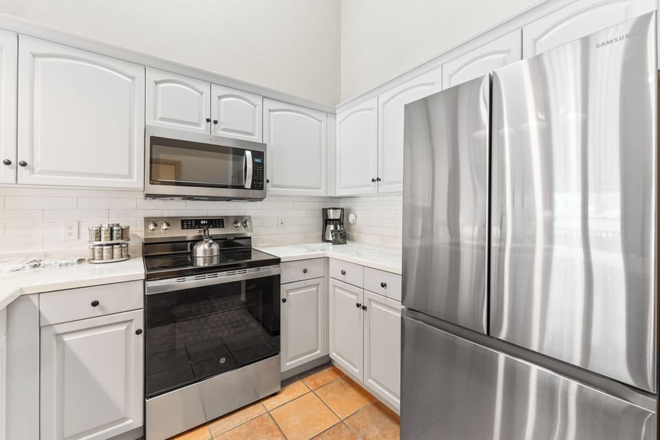 Your fully equipped kitchen features stainless steel appliances, pristine white cabinets, and everything you need to prepare meals during your stay.