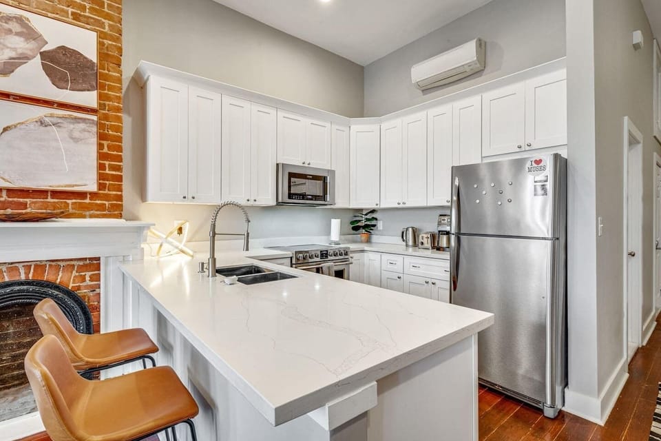 Bright white kitchen w/ bar area — great for cooking in or grabbing a quick bite.
