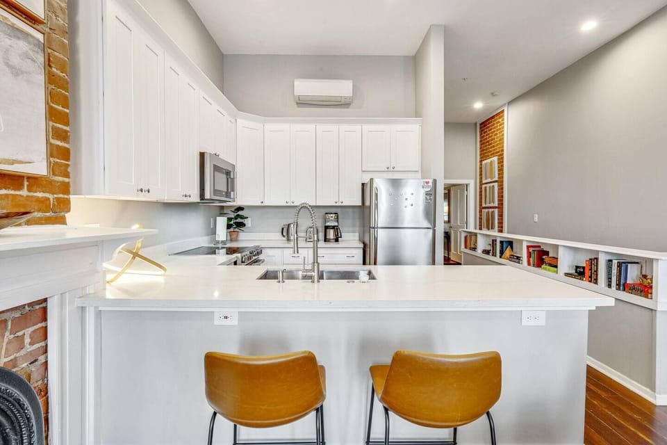 Sleek white kitchen & bar area w/ plenty of counter space for hosting.
