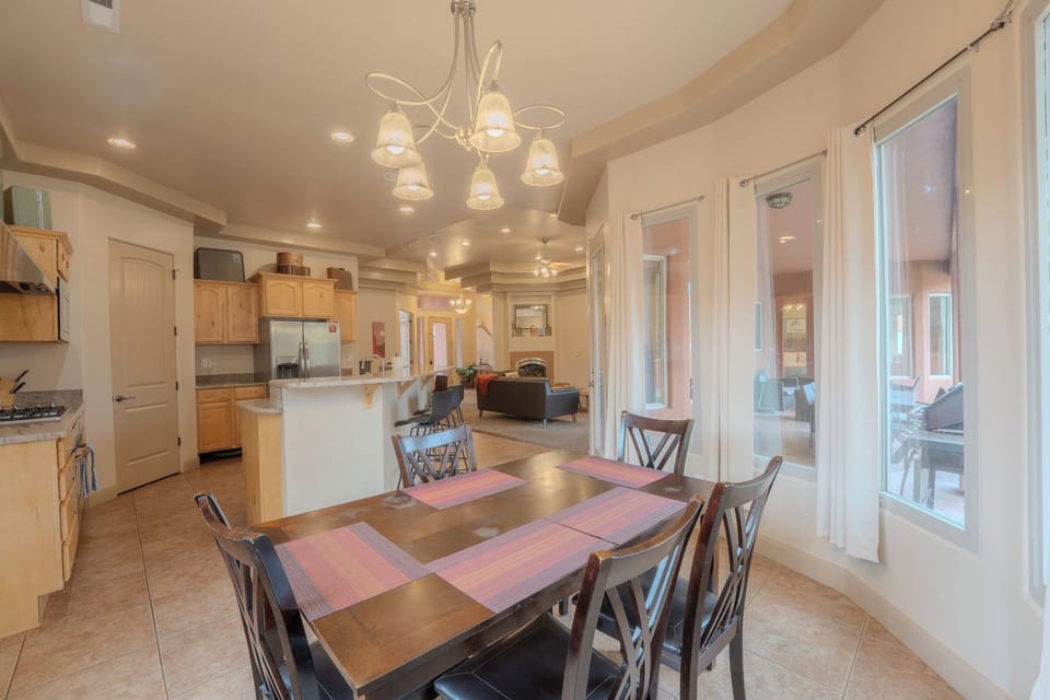 Cozy dining nook with chandelier lighting, flowing into the kitchen and living room at Spirit of the Rock, Kanab.