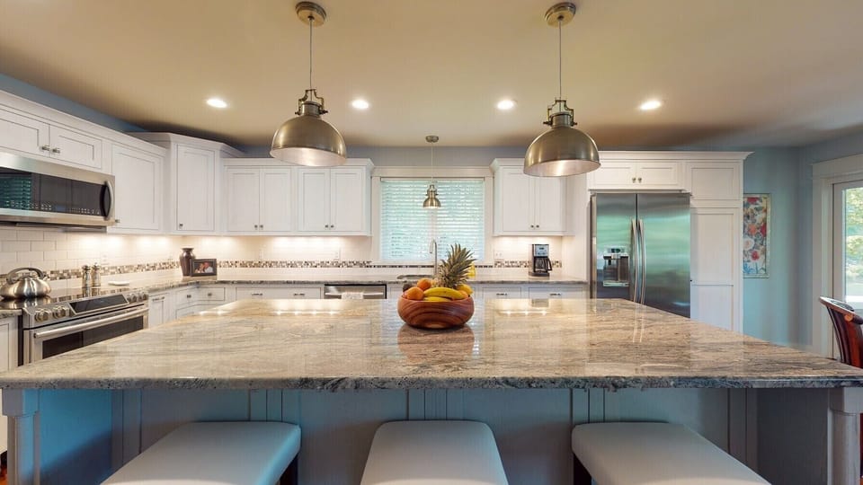 4 by 8 ft granite island seats 3-4 and opens to living room and screen porch