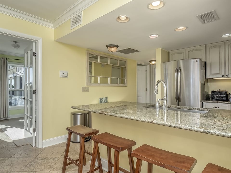 The master bedroom sits just off the kitchen behind glassed French doors.