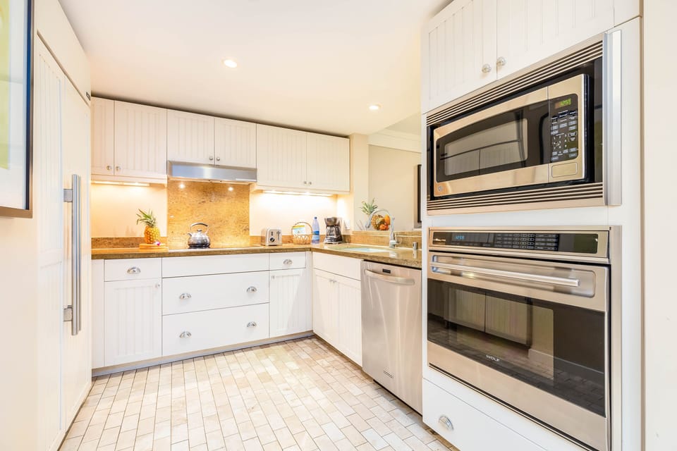 Beautiful modern kitchen equipped with stainless steel appliances, plenty of storage, and warm lighting.