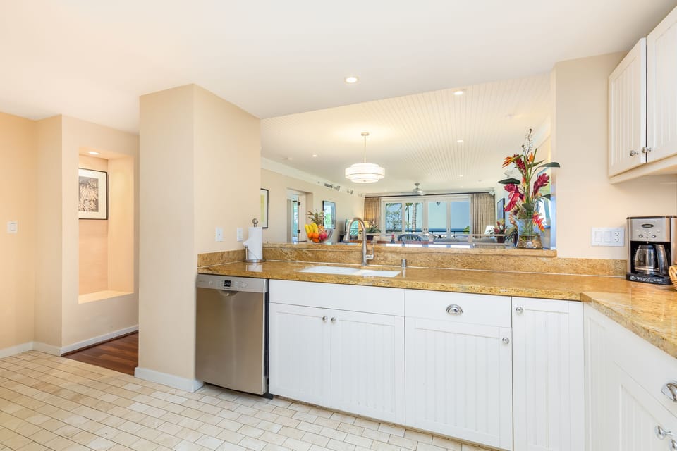 Kitchen with granite countertops and white cabinetry.