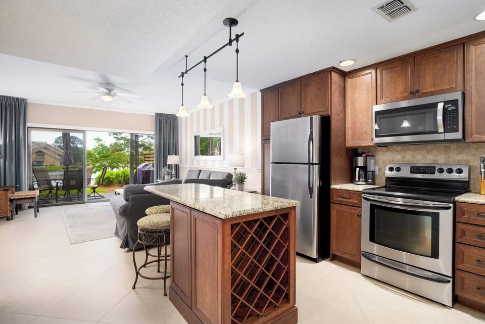 Kitchen island with 2 bar stools and additional additional bar seating. 