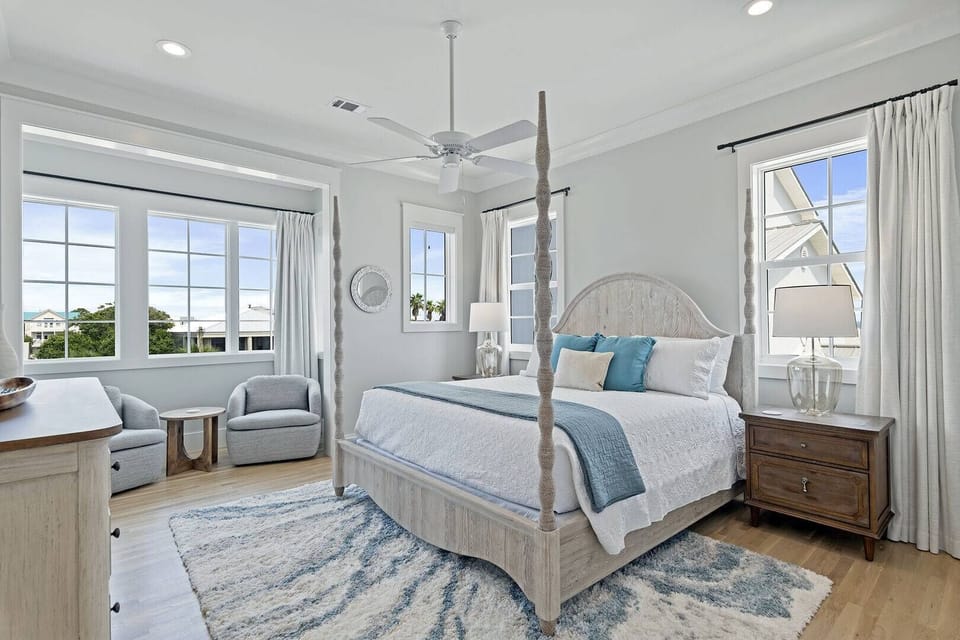 Sunny bedroom w/ twin beds, soft textures & large windows.
