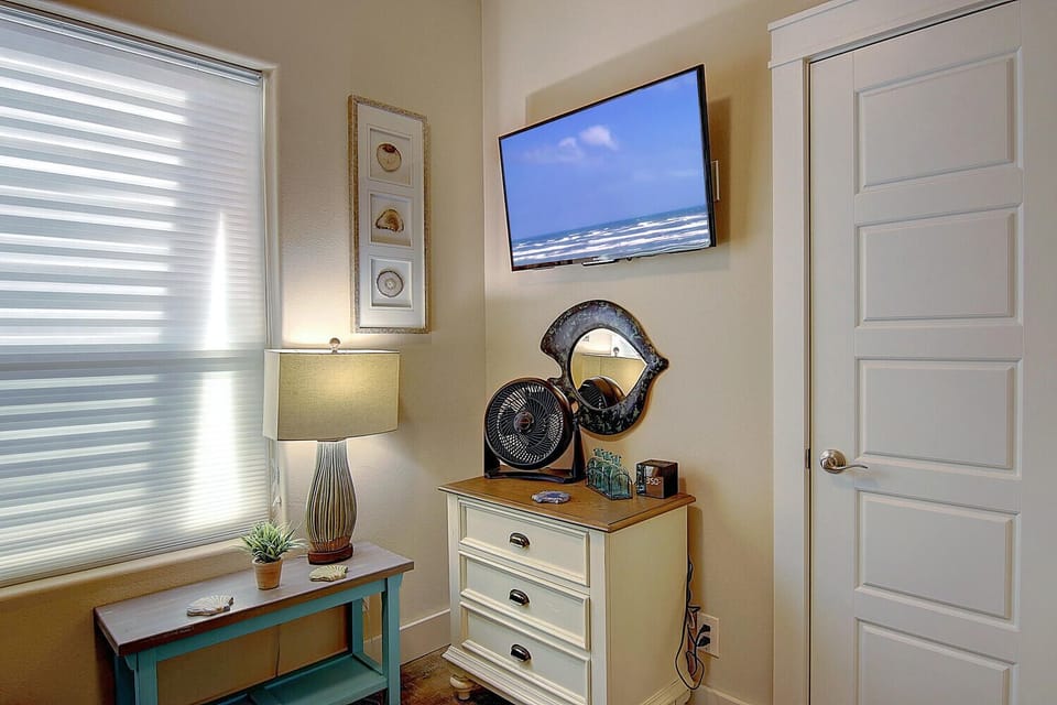 Unwind in your thoughtfully appointed space with a wall-mounted TV, coastal artwork, and charming nautical touches that create a serene retreat atmosphere.